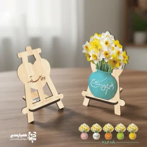 استند چوبی او خواهد آمد استند چوبی طرح «او خواهد آمد» با گلدان زرد و دسته‌ای گل نرگس، تزئینی معنادار و زیبا برای میز یا قفسه. مناسب هدیه مذهبی و یادبود انتظار.