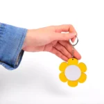 جا کلیدی آیینه دار گلی جاکلیدی گِلی آینه‌دار همیار مدیر، محصولی زیبا و کاربردی با طراحی ظریف و دخترانه است که به‌طور ویژه برای مراسم جشن تکلیف طراحی شده است.💖 این جاکلیدی با ابعاد حدود ۴ سانتی‌متر و وزن تقریبی ۱۰ گرم، بسیار سبک بوده و به‌راحتی قابل استفاده برای کودکان و نوجوانان می‌باشد. وجود آینه در طراحی این جاکلیدی، آن را به هدیه‌ای کاربردی و در عین حال جذاب تبدیل کرده و طراحی گل‌دار آن حس لطافت و شادی را منتقل می‌کند.🌸 این محصول در سه رنگ شاد صورتی، بنفش و زرد عرضه می‌شود که به‌خوبی با فضای جشن تکلیف هماهنگ است.✨ مدارس و مراکز آموزشی می‌توانند نام مدرسه یا مجموعه خود را در پشت جاکلیدی درج کرده و آن را به‌عنوان یک گیفت اختصاصی در کنار سایر هدایای جشن تکلیف به دانش‌آموزان اهدا کنند.🌸 این جاکلیدی یکی از محصولات خاص و مناسبتی همیار مدیر است که با هدف ماندگاری خاطره‌ای شیرین از جشن تکلیف طراحی شده است.