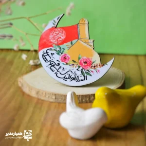 " 🌙 مگنت طرح ماهِ حسینی — تجلی عشق در روشنای ایمان مگنت طرح ماهِ حسینی، با طراحی نمادین از ماه و گنبد طلایی، یادآور نوری است که از دل کربلا تا ابدیت می‌تابد. فضا و رنگ‌آمیزی این اثر هنری، تلفیقی از ایمان، ایثار و زیبایی است که دل هر بیننده را روشن می‌کند ✨ گل‌های قرمز و پرچم عاشورایی، پیام عشق و وفاداری را در قالبی لطیف و معنوی به مخاطب منتقل می‌کنند 🌹 ✨ ویژگی‌های شاخص محصول: 🎨 طراحی ماه‌گون و گنبد طلایی با خوش‌نویسی 🌺 ترکیب رنگ‌های معنوی شامل طلایی، سرخ و سفید که فضای مذهبی آرامش‌بخشی ایجاد می‌کند 🕊️ نماد عشق و امید حسینی؛ مناسب برای تزئین تخته، یخچال یا میز کار در محیط‌های فرهنگی 🎁 هدیه‌ای ارزنده برای دانش‌آموزان در ایام محرم یا برنامه‌های مذهبی مدارس 🏫 گزینه‌ای زیبا برای فضاهای آموزشی؛ ترویج معنویت در قالب هنر ظریف و ماندگار این مگنت دل‌انگیز، نه فقط یک طرح، بلکه چراغی است از ماهِ عشق که بر قلب‌ها می‌تابد 🌙❤️ رو به خورشید دانایی بمان 🌻 "