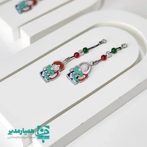 🇮🇷✨ آویز ایران من یکی از محصولات خاص و ارزشمند همیار مدیر است که با الهام از مفاهیم ملی، میهن‌دوستی و هویت ایرانی، برای مناسبت‌های مهمی همچون دهه فجر انقلاب اسلامی و روز دانش‌آموز طراحی شده است. این محصول از جنس پلکسی ساخته شده و با ابعاد ۳.۵ سانتی‌متر و وزن بسیار سبک حدود ۵ گرم، گزینه‌ای مناسب برای استفاده روزمره کودکان و نوجوانان می‌باشد. 🎨❤️ طراحی این آویز شامل آویز تصویری از دختر و پسر است که کشور ایران را در آغوش گرفته‌اند؛ نمادی زیبا از عشق به میهن و همبستگی ملی. در قسمت بالای آویز نیز سه مهره به ترتیب رنگ‌های پرچم ایران 🚩 قرار گرفته که جلوه‌ای خاص و چشم‌نواز به محصول بخشیده است. 🎁✨ این آوثیز پلکسی می‌تواند به عنوان یک گیفت فرهنگی ماندگار در مدارس، مساجد و مؤسسات فرهنگی مورد استفاده قرار گیرد و انتخابی مناسب برای هدیه دادن به دانش‌آموزان در برنامه‌ها و جشن‌های مناسبتی باشد.