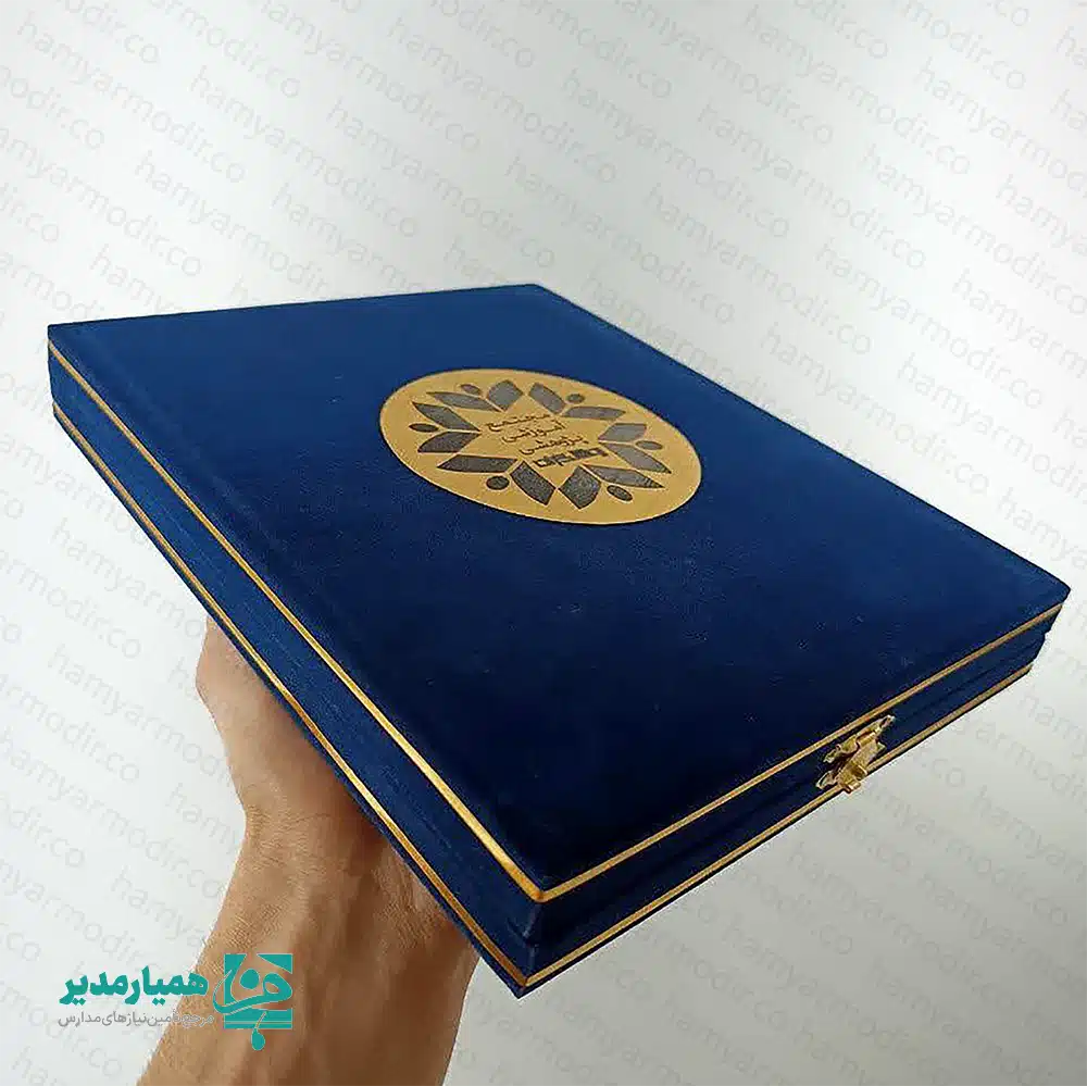 🌟 لوح تقدیر جعبه‌مخمل یک هدیه رسمی، شیک و ماندگار برای تقدیر از معلمان، مربیان و کادر آموزشی است؛ هدیه‌ای که هم ارزش فرهنگی دارد و هم ظاهری بسیار آراسته و محترمانه ارائه می‌کند. این محصول با ابعاد استاندارد ۲۲×۱۵ سانتی‌متر (A5) طراحی شده و ترکیبی از جعبه مخمل مرغوب و بدنه مقاوم مولتی‌پل است که باعث می‌شود هم ظاهر آن لوکس باشد و هم دوام بالایی برای نگهداری در طولانی‌مدت داشته باشد. درون جعبه، یک پلاک طلایی با طرح و متن تقدیر رسمی قرار گرفته که جلوه‌ای کاملاً رسمی و مناسب برای مراسم تقدیر، روز معلم، جشن پایان سال، برنامه‌های آموزشی و فرهنگی دارد. رنگ‌بندی جذاب و پوشش مخملی جعبه، این لوح تقدیر را به هدیه‌ای بسیار ارزشمند تبدیل می‌کند. هدیه ویژه روز معلم 👩‍🏫💐 مناسب برای مدارس، آموزشگاه‌ها، ادارات و مجموعه‌های فرهنگی طراحی لوکس با جعبه مخملی و قفل طلایی کیفیت بالا و مناسب نگهداری در طولانی‌مدت پلاک طلایی با متن رسمی تقدیر اگر به دنبال یک هدیه رسمی و در عین حال مقرون‌به‌صرفه برای برنامه‌های فرهنگی و مناسبتی هستید، لوح تقدیر جعبه‌مخمل A5 یک انتخاب ایده‌آل و حرفه‌ای است که رضایت کامل مخاطب را به همراه خواهد داشت. ✨