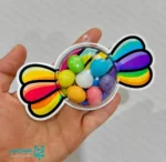 گیفت طرح شکلات رنگی‌رنگی؛ هدیه‌ای شاد و هیجان‌انگیز برای روز دانش‌آموز 🍬🌈 روز دانش‌آموز یکی از شیرین‌ترین و خاطره‌انگیزترین مناسبت‌های مدارس است؛ روزی که با هدیه‌های کوچک اما دوست‌داشتنی، شادی و انگیزه بیشتری به دانش‌آموزان بخشیده می‌شود. گیفت طرح شکلات رنگی‌رنگی دقیقاً با همین هدف طراحی شده است؛ محصولی زیبا، سبک و کاملاً مناسب برای هدایا و پک‌های فرهنگی مدرسه. 🎉 این گیفت فانتزی با وزن بسیار سبک ۹ گرم و در ابعاد استاندارد ۳×۶ سانتی‌متر تولید شده است. طراحی شاد و رنگارنگ آن باعث می‌شود کودکان در اولین نگاه جذبش شوند و حس شیرین دریافت یک هدیه خاص را تجربه کنند. ظاهر آن به شکل شکلات رنگی طراحی شده و کاملاً مناسب جشن‌ها، مناسبت‌ها، تولدها و روز دانش‌آموز است. 🌟🍭 🎁✨ نکته مهم این گیفت، بدون خوراکی بودن آن است. این ویژگی به شما امکان می‌دهد داخل گیفت را با هرچیزی که دوست داشته باشید پر کنید؛ از وسایل آموزشی کوچک گرفته تا شکلات، اسمارتیز، تزیینات فومی یا یادداشت‌های انگیزشی. این انعطاف‌پذیری باعث شده انتخابی عالی برای معلمان، مربیان و مدارس باشد. 🏫💖 گیفت شکلات رنگی‌رنگی به‌ویژه برای مقاطع پیش‌دبستان و دبستان طراحی شده و به‌راحتی در پک‌های فرهنگی، بسته‌های هدیه، جوایز مسابقه‌ای و مناسبت‌های مدرسه قرار می‌گیرد. رنگ‌بندی جذاب، ظاهر کودکانه و ساختار باکیفیت آن، این محصول را به یکی از محبوب‌ترین انتخاب‌ها برای هدیه‌های دانش‌آموزی تبدیل کرده است. 🎈🌟 اگر به دنبال هدیه‌ای مقرون‌به‌صرفه، شاد، قابل‌شخصی‌سازی و مناسب سنین پایین هستید، گیفت طرح شکلات رنگی‌رنگی گزینه‌ای فوق‌العاده و کاملاً کاربردی است.