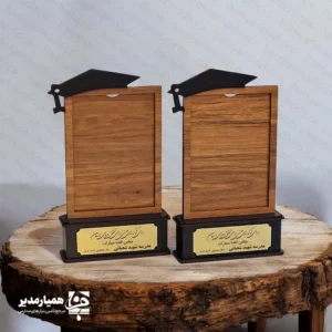قاب عکس چوبی فارغ‌التحصیلی پایه‌دار – یادگاری ماندگار از روزهای مدرسه 🎓✨ قاب عکس چوبی فارغ‌التحصیلی پایه‌دار یکی از محصولات زیبا و خاص مجموعه همیار مدیر است که برای ثبت و نگهداری خاطرات ارزشمند دوران تحصیل طراحی شده است. این قاب از چوب با کیفیت ساخته شده و با ظاهر شیک و رسمی خود جلوه‌ای خاص به عکس‌های فارغ‌التحصیلی می‌بخشد. 📸 این محصول در دو اندازه استاندارد ۱۰×۱۵ و ۱۳×۱۸ سانتی‌متر تولید شده و با وزن سبک ۷۰ گرم به‌راحتی قابل قرارگیری روی میز، قفسه یا ویترین یادگاری‌ها است. وجود پایه محکم در طراحی قاب، آن را برای نمایش عکس‌های فارغ‌التحصیلی بسیار مناسب کرده است. قاب عکس فارغ‌التحصیلی برای تمامی مقاطع تحصیلی از دبستان تا دبیرستان قابل استفاده است و می‌تواند در مراسم پایان سال تحصیلی، جشن فارغ‌التحصیلی و برنامه‌های تقدیر از دانش‌آموزان به عنوان یک هدیه فرهنگی و یادگاری ارزشمند اهدا شود. 🎁 اگر می‌خواهید برای دانش‌آموزان خود یادگاری ماندگار از سال‌های تحصیل بسازید، این قاب چوبی زیبا انتخابی مناسب و خاطره‌انگیز خواهد بود؛ هدیه‌ای که سال‌ها بعد نیز یادآور لحظات شیرین مدرسه خواهد بود. 🌟