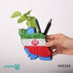 🌹 جاقلمی گلدار طرح ایران – ترکیبی از زیبایی ملی و حس زندگی 🌹 این جاقلمی زیبا و منحصر به فرد با الهام از شکوه و زیبایی سرزمین ایران طراحی شده است. طرح پرچم سه‌رنگ ایران 🇮🇷 در کنار گل‌های زیبا، نشان‌دهنده عشق به وطن و حس سرزندگی است که به فضای کاری یا تحصیلی شما طراوت خاصی می‌بخشد. ساخته شده از جنس چوب و شیشه‌ای، این جاقلمی سبک وزن (۴۰ گرم) با ابعاد مناسب 7.5×12 سانتی‌متر، نه تنها یک ابزار کاربردی است بلکه یک قطعه هنری با معنای ویژه محسوب می‌شود. وجود لوله شیشه‌ای کوچک در داخل جاقلمی، امکان قرار دادن یک شاخه گل طبیعی یا مصنوعی را فراهم کرده تا فضای میز شما را زندگی و زیبایی بدهد. این جاقلمی انتخابی مناسب برای دهه فجر، بازگشایی مدارس و هدیه‌های مناسبتی روز دانش‌آموز است. انتخاب شما برای جاقلمی گلدار طرح ایران، هم یک ابزار کارآمد و هم نشانی از احترام به فرهنگ و سرزمین‌مان است. این محصول بدون گل ارسال می‌شود، اما فرصتی برای شماست تا حس زندگی را به سبک خودتان خلق کنید. 🌱✨