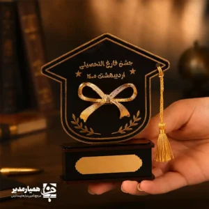 🎓 تندیس مینیاتوری پاپیون فارغ‌التحصیلی – نمادی از موفقیت و آغاز راه جدید 🎓 جلوه‌ای خاص و خاطره‌انگیز برای جشن‌های فارغ‌التحصیلی دانش‌آموزان با این تندیس زیبا و باکیفیت که توسط همیار مدیر طراحی شده است. این تندیس مینیاتوری از جنس چوب و فلز ساخته شده و با وزن سبک ۳۰ گرم، مناسب برای نگهداری و نمایش در میز یا کمد دانش‌آموزان است. ابعاد آن شامل پایه‌ای با اندازه‌های ۷.۵×۳×۲.۵ سانتی‌متر و کلاه فارغ‌التحصیلی به ابعاد ۱۰×۱۱ سانتی‌متر است که ترکیبی از ظرافت و قابلیتی ایده‌آل برای ساخت یک هدیه ماندگار ایجاد کرده است. این تندیس گزینه‌ای مناسب برای تمامی مقاطع تحصیلی بوده و برای هر دو گروه دختران و پسران می‌تواند یادگاری ارزشمندی باشد. شما می‌توانید نام، تاریخ یا متن دلخواه خود را روی آن درج کنید تا هدیه‌ای کاملاً شخصی و خاص بسازید. 🎁 با انتخاب این تندیس، علاوه بر تقدیر از تلاش‌های دانش‌آموزان، لحظات جشن فارغ‌التحصیلی را خاطره‌انگیزتر و ماندگارتر کنید و میز آن‌ها را با یک قطعه هنری زیبا و خاص تزئین نمایید.
