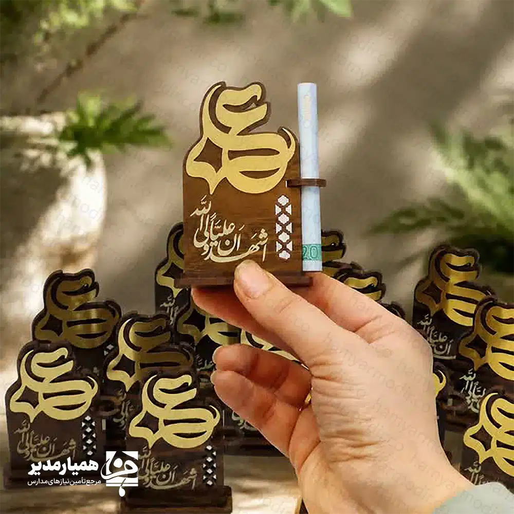 " 🕌✨ استند غدیر کد 4 | هدیه‌ای زیبا، معنوی و مناسب عید غدیر استند غدیر کد ۳ یکی از محصولات خاص و پرفروش همیار مدیر است که با ترکیب هنرمندانه ام‌دی‌اف دورو، ام‌دی‌اف اکلیلی و مولتی‌استایل ساخته شده است. این استند با طراحی ویژه عید غدیر، هم جلوه‌ای بسیار شیک دارد و هم کیفیت ساخت بالایی ارائه می‌دهد. محصول با ارتفاع تقریبی ۸.۵ سانتی‌متر طراحی شده و به‌دلیل ابعاد مناسب و وزن سبک، به‌راحتی داخل پک‌های هدیه قرار می‌گیرد. وجود جای مخصوص اسکناس نیز آن را برای عیدی دادن در عید غدیر بسیار کاربردی و محبوب کرده است 💵✨. در بخش بالایی استند، نام زیبای حضرت علی (ع) با طرحی درخشان حک شده و در قسمت پایین، عبارت دلنشین «اشهدا ان علی....» دیده می‌شود. این ترکیب، استند را به یک یادبود ارزشمند و معنوی برای علاقه‌مندان تبدیل می‌کند. 📌 ویژگی‌های محصول: 📏 ارتفاع: حدود ۸.۵ سانتی‌متر📐 پایه: ۵.۸ سانتی‌متر 🪵 جنس: ام‌دی‌اف دورو + ام‌دی‌اف اکلیلی + مولتی‌استایل 💵 دارای جای مخصوص قرار دادن اسکناس 🕌 طراحی مناسبتی ویژه عید غدیر 🎁 مناسب برای پک‌های هدیه، مدارس و مراسم مذهبی اگر به دنبال هدیه‌ای معنوی، زیبا و در عین حال کاربردی برای عید غدیر هستید، این استند می‌تواند انتخابی عالی برای شما باشد و هدیه‌تان را خاص‌تر و ماندگارتر کند ✨🌿. "