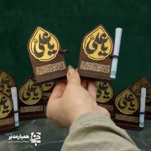 " 🕌✨ استند غدیر کد ۳ | هدیه‌ای زیبا، معنوی و مناسب عید غدیر استند غدیر کد ۳ یکی از محصولات خاص و پرفروش همیار مدیر است که با ترکیب هنرمندانه ام‌دی‌اف دورو، ام‌دی‌اف اکلیلی و مولتی‌استایل ساخته شده است. این استند با طراحی ویژه عید غدیر، هم جلوه‌ای بسیار شیک دارد و هم کیفیت ساخت بالایی ارائه می‌دهد. محصول با ارتفاع تقریبی ۸.۵ سانتی‌متر طراحی شده و به‌دلیل ابعاد مناسب و وزن سبک، به‌راحتی داخل پک‌های هدیه قرار می‌گیرد. وجود جای مخصوص اسکناس نیز آن را برای عیدی دادن در عید غدیر بسیار کاربردی و محبوب کرده است 💵✨. در بخش بالایی استند، نام زیبای حضرت علی (ع) با طرحی درخشان حک شده و در قسمت پایین، عبارت دلنشین «اسلام علیک یا علی بن ابی‌طالب» دیده می‌شود. این ترکیب، استند را به یک یادبود ارزشمند و معنوی برای علاقه‌مندان تبدیل می‌کند. 📌 ویژگی‌های محصول: 📏 ارتفاع: حدود ۸.۵ سانتی‌متر📐 پایه: ۵.۸ سانتی‌متر 🪵 جنس: ام‌دی‌اف دورو + ام‌دی‌اف اکلیلی + مولتی‌استایل 💵 دارای جای مخصوص قرار دادن اسکناس 🕌 طراحی مناسبتی ویژه عید غدیر 🎁 مناسب برای پک‌های هدیه، مدارس و مراسم مذهبی اگر به دنبال هدیه‌ای معنوی، زیبا و در عین حال کاربردی برای عید غدیر هستید، این استند می‌تواند انتخابی عالی برای شما باشد و هدیه‌تان را خاص‌تر و ماندگارتر کند ✨🌿. "