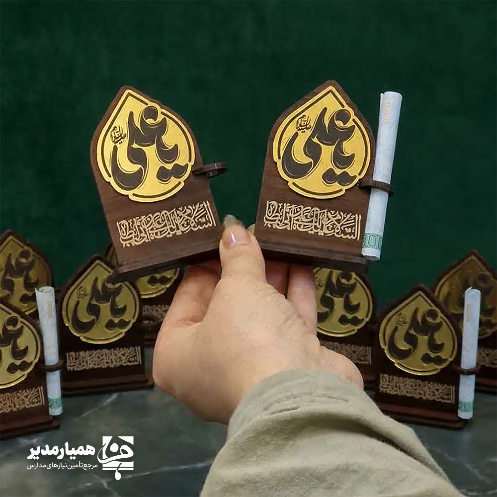 " 🕌✨ استند غدیر کد ۳ | هدیه‌ای زیبا، معنوی و مناسب عید غدیر استند غدیر کد ۳ یکی از محصولات خاص و پرفروش همیار مدیر است که با ترکیب هنرمندانه ام‌دی‌اف دورو، ام‌دی‌اف اکلیلی و مولتی‌استایل ساخته شده است. این استند با طراحی ویژه عید غدیر، هم جلوه‌ای بسیار شیک دارد و هم کیفیت ساخت بالایی ارائه می‌دهد. محصول با ارتفاع تقریبی ۸.۵ سانتی‌متر طراحی شده و به‌دلیل ابعاد مناسب و وزن سبک، به‌راحتی داخل پک‌های هدیه قرار می‌گیرد. وجود جای مخصوص اسکناس نیز آن را برای عیدی دادن در عید غدیر بسیار کاربردی و محبوب کرده است 💵✨. در بخش بالایی استند، نام زیبای حضرت علی (ع) با طرحی درخشان حک شده و در قسمت پایین، عبارت دلنشین «اسلام علیک یا علی بن ابی‌طالب» دیده می‌شود. این ترکیب، استند را به یک یادبود ارزشمند و معنوی برای علاقه‌مندان تبدیل می‌کند. 📌 ویژگی‌های محصول: 📏 ارتفاع: حدود ۸.۵ سانتی‌متر📐 پایه: ۵.۸ سانتی‌متر 🪵 جنس: ام‌دی‌اف دورو + ام‌دی‌اف اکلیلی + مولتی‌استایل 💵 دارای جای مخصوص قرار دادن اسکناس 🕌 طراحی مناسبتی ویژه عید غدیر 🎁 مناسب برای پک‌های هدیه، مدارس و مراسم مذهبی اگر به دنبال هدیه‌ای معنوی، زیبا و در عین حال کاربردی برای عید غدیر هستید، این استند می‌تواند انتخابی عالی برای شما باشد و هدیه‌تان را خاص‌تر و ماندگارتر کند ✨🌿. "