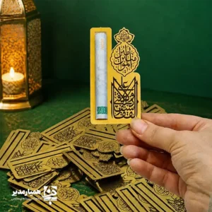🕌✨ گیفت اسکناس کد ۵؛ هدیه‌ای با شکوه از جنس هنر و معنا اگر به دنبال هدیه‌ای خاص، فرهنگی و ماندگار برای جشن بزرگ غدیر هستید، گیفت اسکناس کد ۵ یکی از بهترین انتخاب‌هاست. این محصول با طراحی اختصاصی مجموعه همیار مدیر ساخته شده تا عیدی دادن را زیباتر، شکیل‌تر و معنادارتر کند 💚. بدنه‌ی این گیفت از مولتی‌استایل طلایی براق تهیه شده است؛ جنسی سبک، مقاوم و بسیار چشمگیر که در کنار وزن تنها ۳ گرم، محصولی ظریف و کاربردی را به وجود آورده است. ابعاد ۹ سانتی‌متری آن نیز باعث می‌شود به‌راحتی در انواع پک‌های هدیه دانش‌آموزی یا بسته‌های مناسبتی قرار بگیرد 🎁✨. ویژگی برجسته‌ی این مدل، متن خوش‌نویسی‌شده‌ی «لَا فَتَی إلّا عَلِیّ وَ لَا سَیْفَ إلّا ذُوالْفَقَارِ» است؛ عبارتی که هم بار معنایی عمیق دارد و هم جلوه‌ای فاخر و هنری به گیفت می‌دهد. این نوشته در کنار ترکیب رنگ طلایی، حس شکوه و اصالت را به‌خوبی منتقل می‌کند 🖋️🌟. طراحی این گیفت به‌گونه‌ای انجام شده که اسکناس را می‌توان به‌سادگی داخل آن قرار داد و بدون دردسر خارج کرد؛ بنابراین هم برای استفاده‌ی شخصی و هم برای تهیه‌ی پک‌های هدیه، کاملاً مناسب است. اگر می‌خواهید هدیه‌ای بدهید که هم زیبا باشد و هم پیام فرهنگی و مذهبی داشته باشد، این مدل انتخابی هوشمندانه است 🌿. 📌 مشخصات فنی محصول: 📏 ابعاد: ۹ سانتی‌متر ⚖️ وزن: ۳ گرم 🪵 جنس: مولتی‌استایل طلایی 🖋️ متن: «لَا فَتَی إلّا عَلِیّ وَ لَا سَیْفَ إلّا ذُوالْفَقَارِ» 💰 کاربرد: جای اسکناس با قابلیت قرار دادن و خارج کردن آسان پول 🎀 مناسب برای: هدیه دانش‌آموزی، جشن غدیر و پک‌های مناسبتی 🌟 طراحی: اختصاصی همیار مدیر گیفت اسکناس کد ۵ فقط یک جای پول نیست؛ یک یادگار فرهنگیِ زیباست که می‌تواند ارزش هدیه شما را چند برابر کند ✨💚.