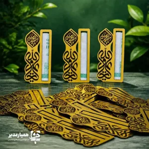 🕌✨ گیفت اسکناس کد ۴؛ تلفیق هنر خطاطی و درخشش طلایی عیدی دادن در روز غدیر، سنتی است که با گیفت اسکناس کد ۴ به یک خاطره ماندگار تبدیل می‌شود. ما در تیم همیار مدیر، این محصول را با تمرکز بر شکوهِ نام امیرالمؤمنین (ع) طراحی کرده‌ایم. حکاکی ظریف عبارت «علی ولی الله» بر روی بدنه طلایی، جلوه‌ای معنوی و در عین حال مدرن به هدیه شما می‌بخشد. استفاده از ورق‌های مولتی‌استایل درجه یک باعث شده تا این گیفت علاوه بر درخشش خیره‌کننده، تنها ۳ گرم وزن داشته باشد. این سبکیِ باورنکردنی در کنار قد ۹ سانتی‌متری، آن را به گزینه‌ای عالی برای قرار گرفتن در انواع پک‌های هدیه، بدون ایجاد سنگینی یا اشغال فضای زیاد، تبدیل کرده است 💵✨. یکی از دغدغه‌های همیشگی در خرید گیفت‌های اسکناس، راحتی استفاده از آن است. طراحی این مدل به‌گونه‌ای مهندسی شده که شیار نگه‌دارنده، اسکناس را به‌طور کاملاً ایمن نگه می‌دارد، اما در عین حال به دانش‌آموز اجازه می‌دهد تا بدون پاره شدن یا مچاله شدن پول، آن را به‌راحتی خارج کند 🎁🌿. 📌 ویژگی‌های فنی و شاخص محصول: 📏 ارتفاع گیفت: ۹ سانتی‌متر ⚖️ وزن: ۳ گرم (فوق سبک و ظریف) 🪵 جنس: مولتی‌استایل طلایی براق (مشابه فلز) 🖋️ طرح: حکاکی لیزری «علی ولی الله» با فونت اختصاصی 💰 کاربری: نگه‌دارنده اسکناس با قابلیت جابجایی آسان پول 🌟 طراحی: طرح اختصاصی و انحصاری مجموعه همیار مدیر اگر به دنبال راهی هستید تا هدایای فرهنگی خود را در جشن غدیر متمایز کنید، این گیفت درخشان بهترین همراه شماست. با همیار مدیر، زیبایی و معنویت را در هم بیامیزید ✨🕌.