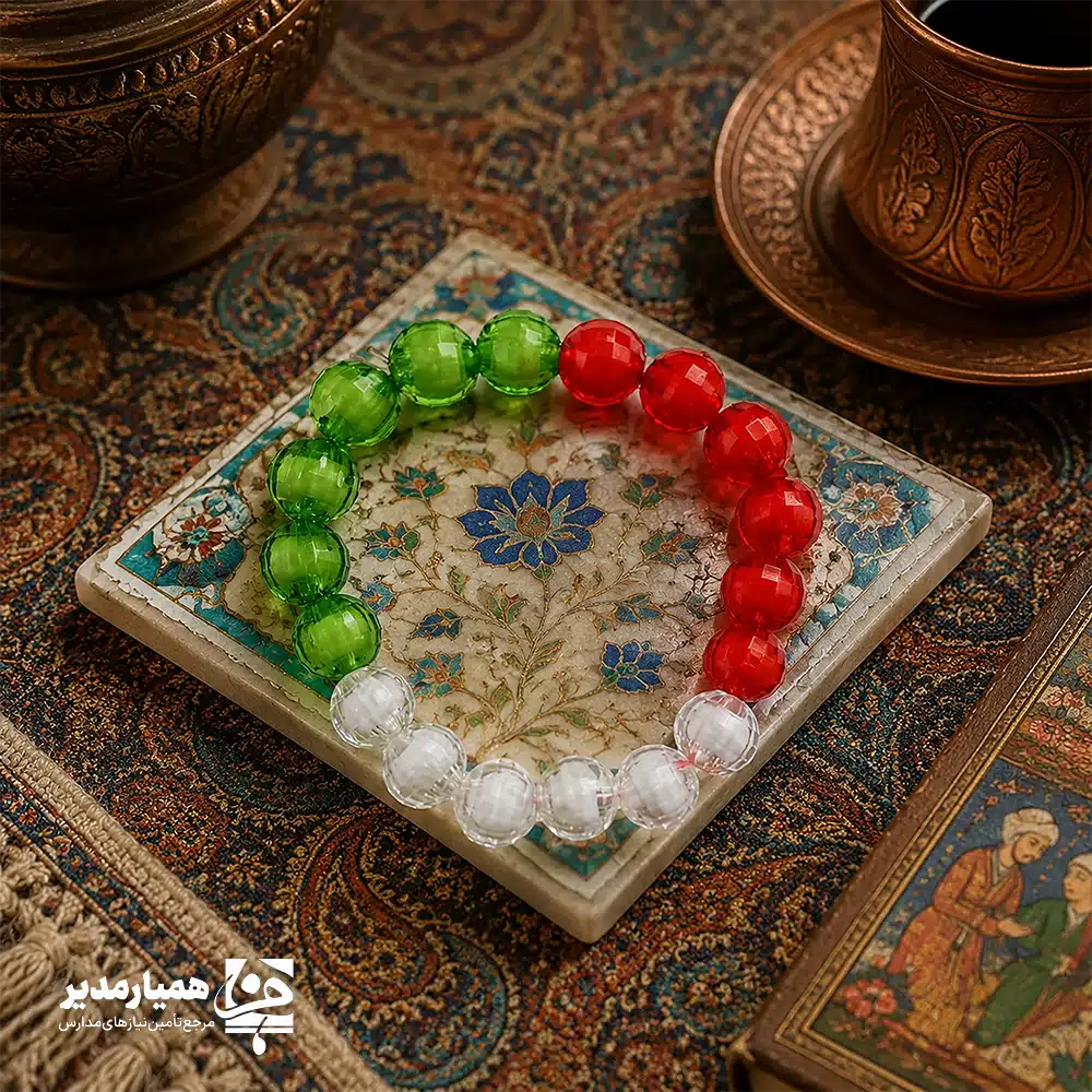 " 🇮🇷 تجلی عشق و وطن در دستبند «ایران من» (ویژه عید غدیر) عید غدیر، بزرگترین عید شیعیان، فرصتی ناب برای پیوند زدن دلهای کودکان با مفهوم ولایت است. دستبند «ایران من» با نگاهی هنرمندانه توسط مجموعه «همیار مدیر» طراحی شده تا این پیام ارزشمند را که ایران همواره سرزمین محبان علی (ع) بوده است، در قالب یک هدیه دوست‌داشتنی به نسل نو منتقل کند. ✨ تحلیل فنی و هنری محصول: ▪️ متریال درخشان: استفاده از مهره‌های شفاف (Crystal-clear beads) در سه رنگ سبز، سفید و قرمز، علاوه بر تداعی پرچم ایران، نور را به‌خوبی منعکس کرده و جلوه‌ای جواهرگونه و جذاب برای کودکان دارد. ▪️ کارت تقدیم اختصاصی: دستبند بر روی یک کارت هنری در ابعاد تقریبی ۵×۵ سانتی‌متر نصب شده است. تصویرسازی فانتزی و باحجاب روی کارت به همراه شعار پرمحتوای «ایران من، دل‌سپرده‌ی عشق علی»، ارزش معنوی هدیه را چندین برابر می‌کند. ▪️ طراحی ارگونومیک: ابعاد دستبند به‌گونه‌ای در نظر گرفته شده که برای مچ دست دانش‌آموزان مقطع ابتدایی کاملاً استاندارد و راحت باشد. 🎁 چرا این محصول برای مراکز فرهنگی و مدارس ایده‌آل است؟ ۱. تقویت هویت دوگانه: این هدیه به‌طور همزمان حس وطن‌دوستی و عشق به اهل‌بیت را در کودک بیدار می‌کند. ۲. قیمت اقتصادی و کیفیت بالا: با توجه به جنس مهره‌ها و بسته‌بندی شکیل، این محصول گزینه‌ای بسیار مقرون‌به‌صرفه برای هدایای جمعی در مدارس و هیئت‌هاست. ۳. پیوستگی محتوایی: اگر از سایر محصولات «همیار مدیر» استفاده می‌کنید، این دستبند تکملی‌کننده پک‌های فرهنگی عید غدیر شما خواهد بود. 🌟 این دستبند صرفاً یک زینت ساده نیست؛ بلکه یک «یادمان فرهنگی» است که در ذهن کودک، خاطره خوشِ عید غدیر را با افتخارِ ایرانی بودن گره می‌زند. انتخابی عالی برای مربیان پرورشی و مدیران خوش‌سلیقه‌ای که به جزئیات تربیتی اهمیت می‌دهند. "