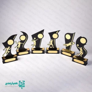 " تندیس ورزشی مدل قهرمان؛ نماد درخشش و پیروزی 🥇✨ تجلیل از تلاش‌های ورزشی دانش‌آموزان، یکی از موثرترین راه‌ها برای تقویت اعتمادبه‌نفس و ایجاد انگیزه در آن‌هاست. تندیس ورزشی چوبی مدل قهرمان، با طراحی پویا و نمادین، به‌خوبی حس حرکت و موفقیت را منتقل می‌کند. این تندیس‌ها به گونه‌ای طراحی شده‌اند که با قرارگیری در دکور اتاق یا بوفه افتخارات دانش‌آموز، همواره خاطره خوش پیروزی را برای او زنده نگه دارند. طراحی هوشمندانه و متریال باکیفیت 🎨 در ساخت این محصول از تکنولوژی برش لیزری دقیق استفاده شده است. بدنه اصلی از چوب MDF مشکی با ضخامت استاندارد و المان‌های ورزشی از پلکسی‌گلاس طلایی (آینه‌ای) ساخته شده‌اند. این ترکیب کنتراست رنگی زیبایی ایجاد کرده و باعث می‌شود تندیس در زیر نور سالن‌های ورزشی درخشش فوق‌العاده‌ای داشته باشد. تنوع رشته‌های ورزشی ⚽🏀🏐 یکی از بزرگترین مزایای مدل «قهرمان»، پوشش تمامی رشته‌های محبوب است. از جمله: فوتبال و فوتسال: با طرح‌های ضربه به توپ و دروازه‌بانی. بسکتبال و والیبال: نمایش فیگورهای تخصصی پرتاب و اسپک. دوومیدانی و آمادگی جسمانی: نماد سرعت و استقامت. هندبال و ورزش‌های رزمی: متناسب با نیاز مسابقات تخصصی. مشخصات فنی و ابعادی 📌 جنس بدنه: MDF درجه یک و پلکسی‌گلاس طلایی پایه: دارای پایه چوبی مستحکم (قابلیت نصب پلاک حکاکی شده) رنگ‌بندی: ترکیب مشکی و طلایی (بسیار رسمی و لوکس) کاربرد: المپیادهای ورزشی، جشن‌های پایان سال، مسابقات محلی 💡 پیشنهاد برای مدارس: پایه پهن این تندیس این امکان را به شما می‌دهد تا نام دانش‌آموز، نام مدرسه و سال تحصیلی را روی یک لیبل طلایی چاپ کرده و در قسمت جلوی پایه بچسبانید تا هدیه کاملاً اختصاصی و ماندگار شود. "