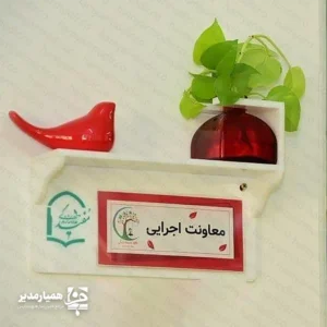  تابلو ی چوبی سر در حس خوب ؛ ترکیب زیبایی و نظم در فضای اداری تابلو چوبی سر در حس خوب راهکاری حرفه‌ای برای نظم‌دهی و زیباسازی فضاهای اداری و آموزشی است. این تابلو با طراحی مدرن  علاوه بر معرفی اتاق‌ها، جلوه‌ای شیک و منظم به محیط کار شما می‌بخشد. استفاده از متریال  پلکسی گلاس در ساخت این محصول باعث شده تا در برابر گردوغبار، رطوبت و ضربه مقاومت بالایی داشته باشد. بنابراین این تابلو گزینه‌ای مناسب برای نصب در مدارس، شرکت‌ها، سازمان‌ها و موسسات آموزشی محسوب می‌شود. ویژگی‌های اصلی محصول ساخته شده از پلکسی گلاس باکیفیت طراحی مدرن و جذاب مناسب محیط‌های اداری و آموزشی مقاوم در برابر گردوغبار و ضربه نصب آسان روی دیوار یا درب اتاق مناسب برای معرفی اتاق مدیریت، کلاس‌ها و بخش‌های مختلف سازمان همراه با گلدان(بدون گل) و پرنده سفالی امکان سفارشی‌سازی یکی از مهم‌ترین مزایای این محصول، امکان طراحی اختصاصی است. شما می‌توانید نام اتاق، لوگوی مجموعه یا هر متن دلخواه را روی تابلو درج کنید تا هویت بصری سازمان شما به شکلی حرفه‌ای نمایش داده شود. این تابلو گزینه‌ای ایده‌آل برای مدارس، شرکت‌ها، دفاتر اداری و موسسات آموزشی است و به مراجعه‌کنندگان کمک می‌کند مسیر خود را سریع‌تر پیدا کنند، در حالی که ظاهر محیط نیز مرتب و حرفه‌ای باقی می‌ماند.